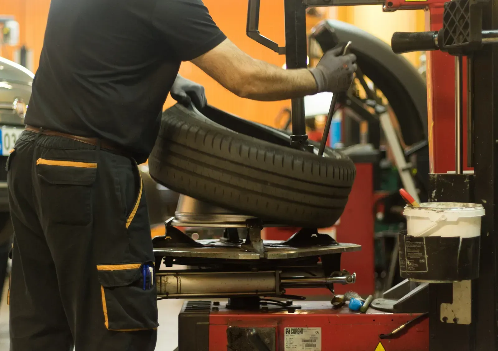 Un home està canviant un pneumàtic d'una màquina en un garatge.