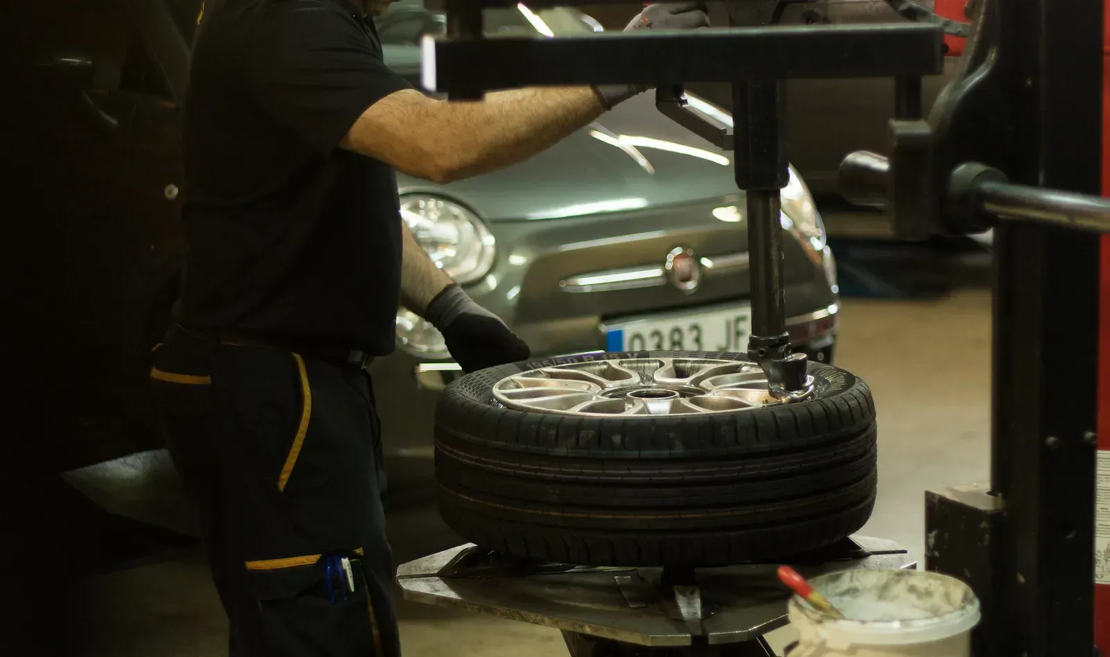 Un home està canviant una roda en un garatge.