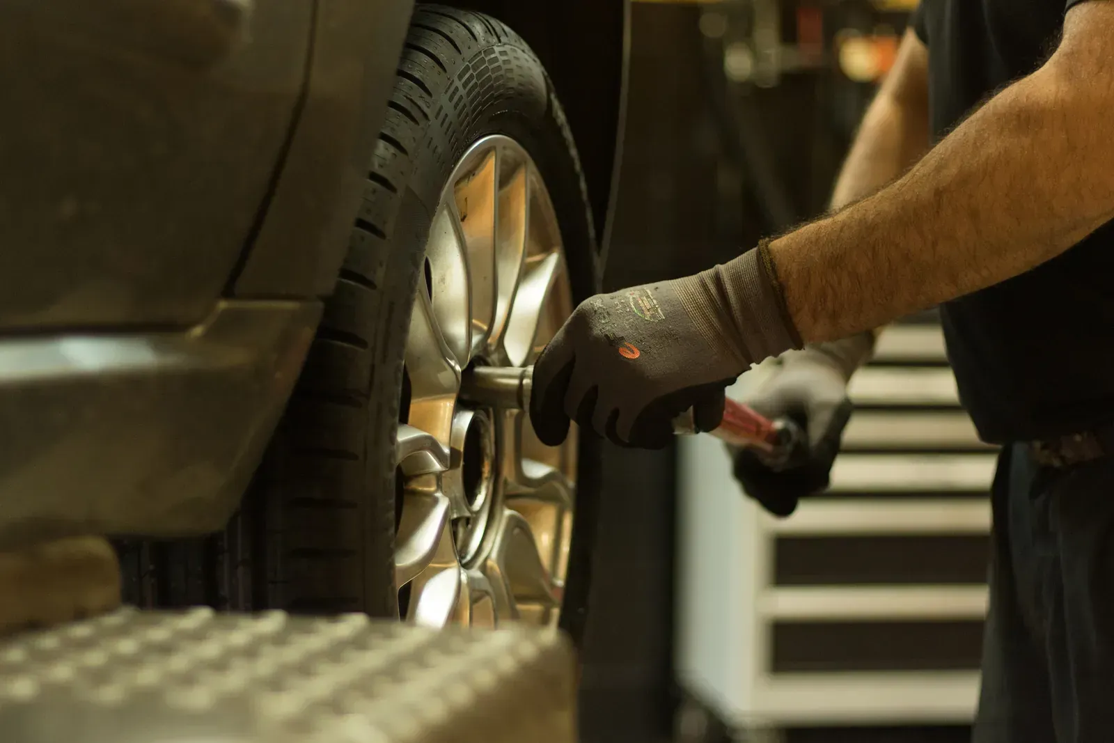 Un home està canviant una roda d'un cotxe en un garatge.