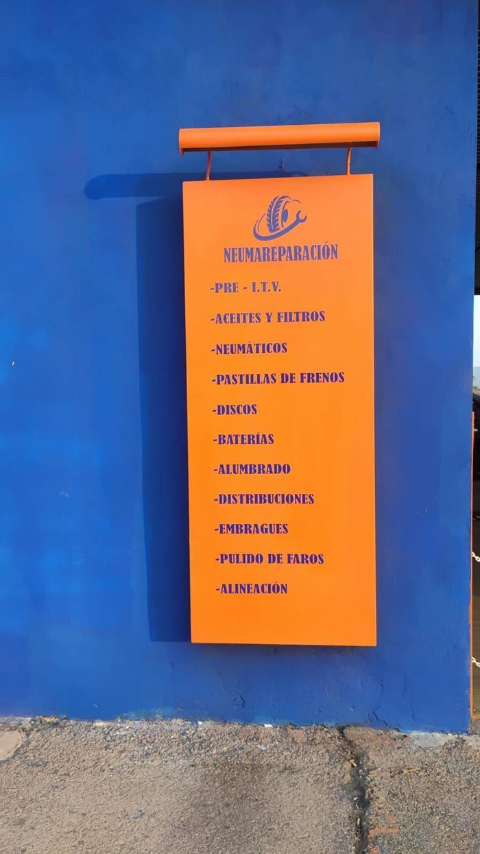 Un cartel naranja cuelga en una pared azul.