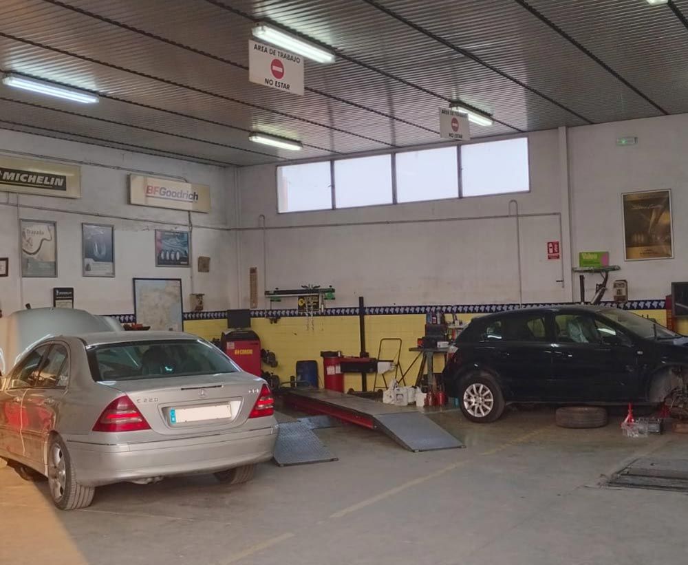 Dos coches están aparcados en un garaje con un cartel que dice no aparcar.