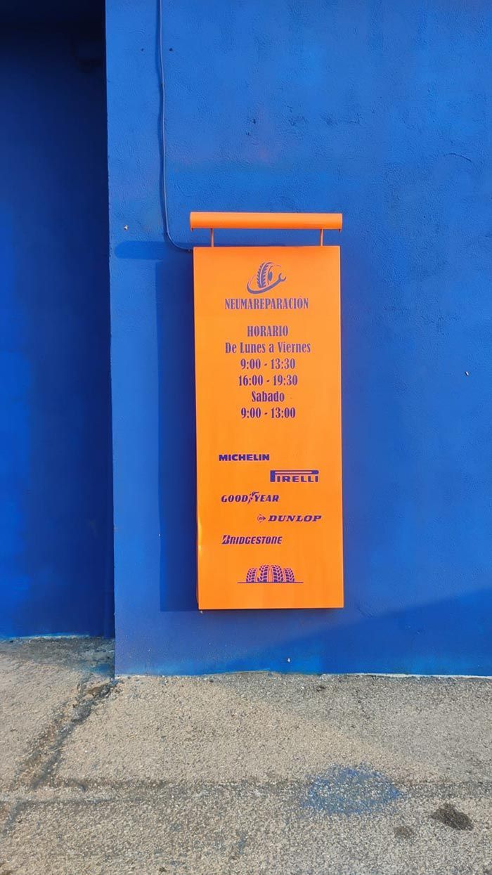 Un cartel naranja cuelga en una pared azul.