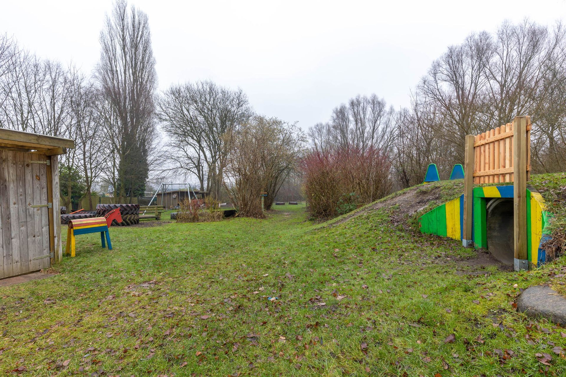 Es gibt einen Spielplatz inmitten einer Wiese.