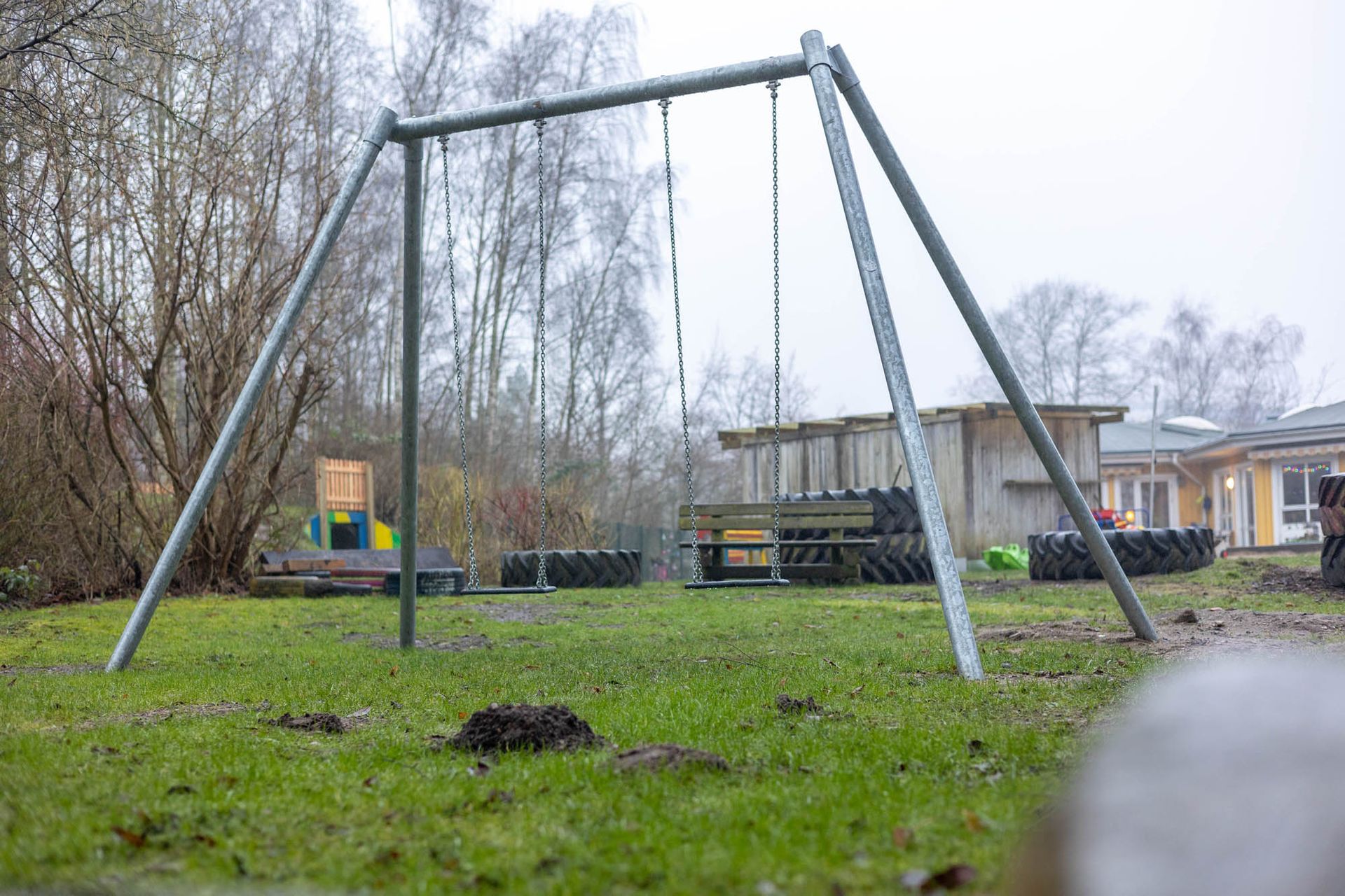 Eine Schaukel steht mitten auf einer Wiese.