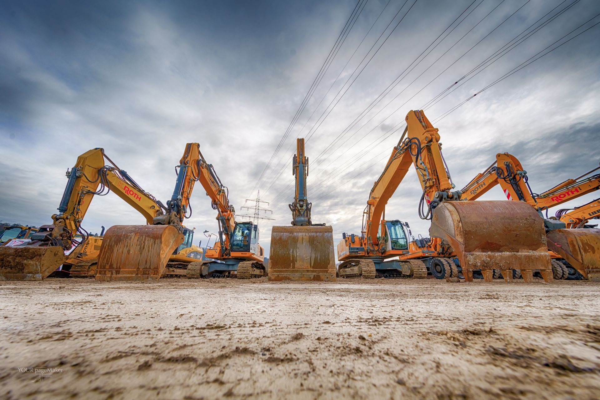 Eine Gruppe von Baufahrzeugen ist auf einem Feld geparkt.