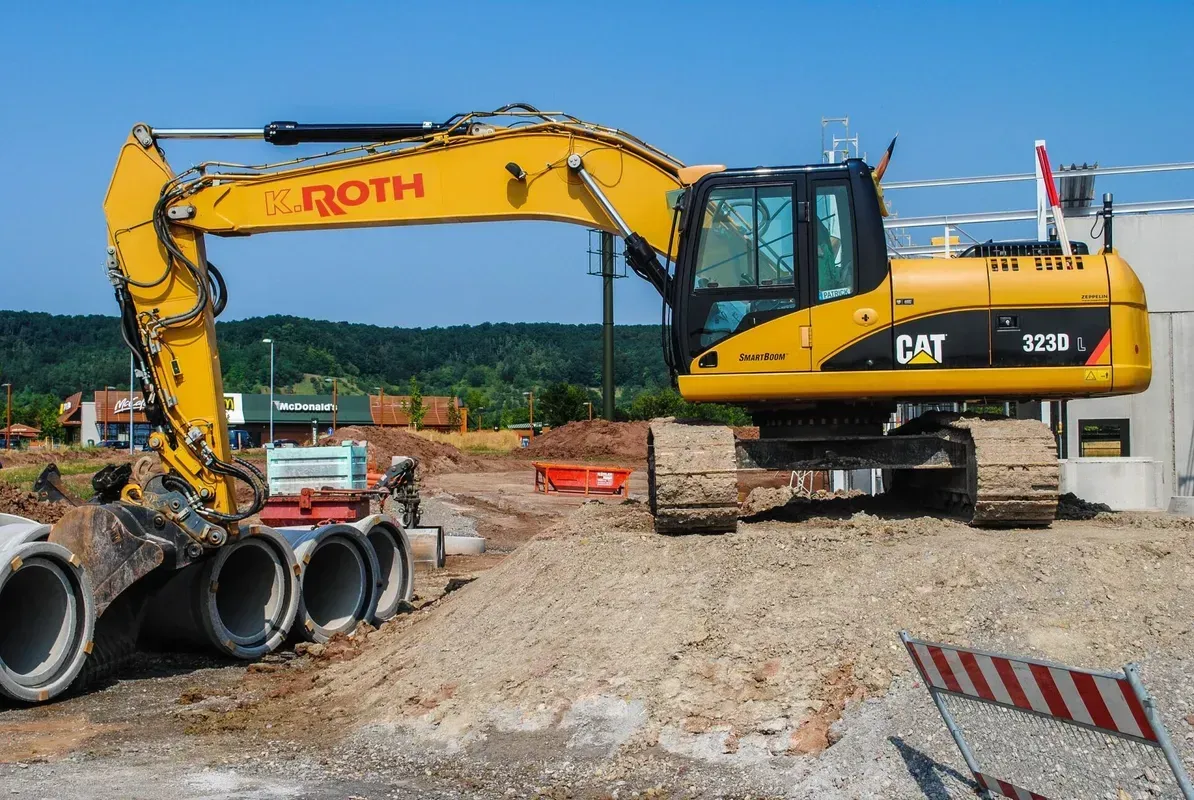 Auf einer Baustelle steht ein gelber Bagger.