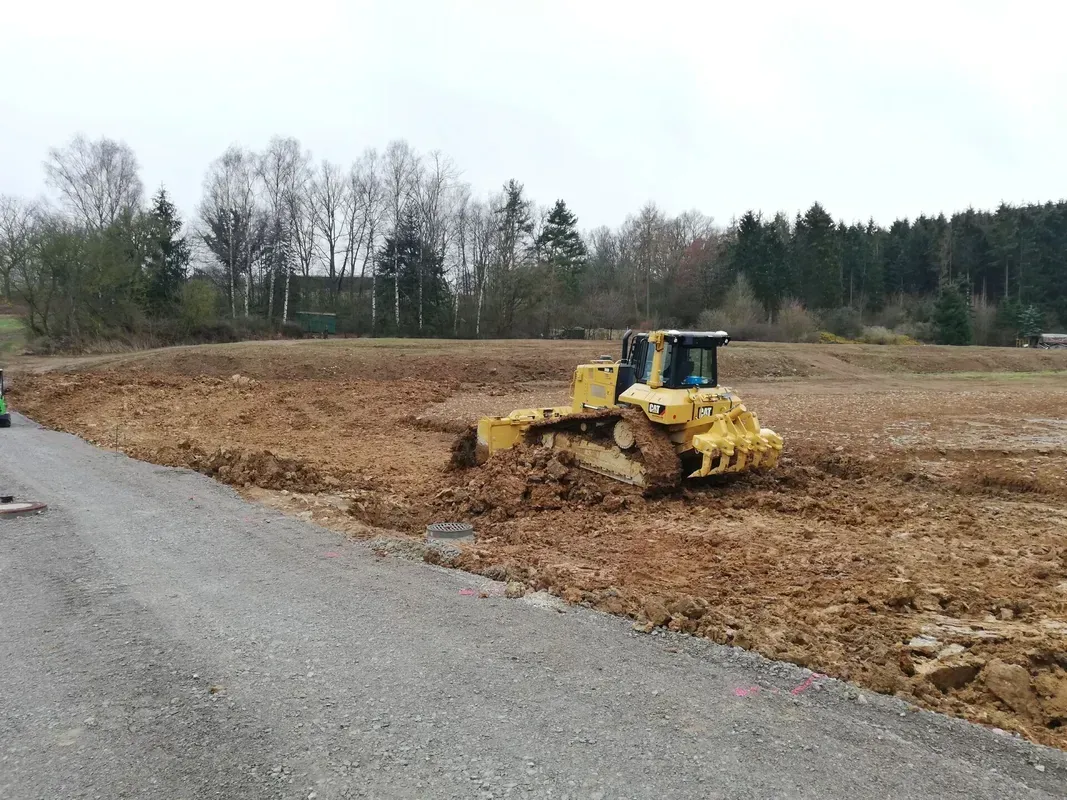 Eine Planierraupe bewegt Erde auf einem Feld.