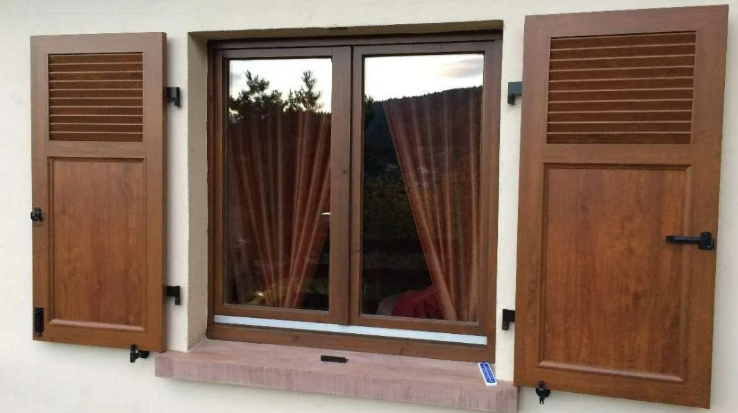 Une fenêtre et des volets en bois foncé.