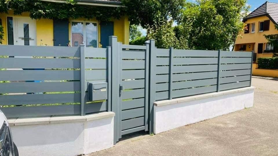 Un portillon et des palissades.