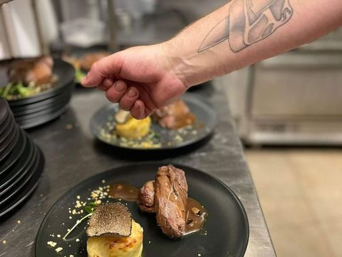 Une main salant un plat
