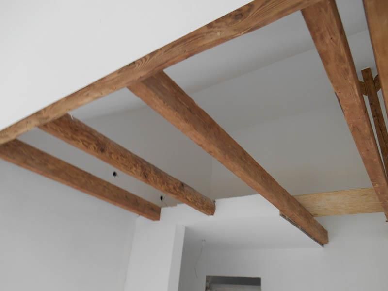 Eine Decke mit Holzbalken und weißen Wänden