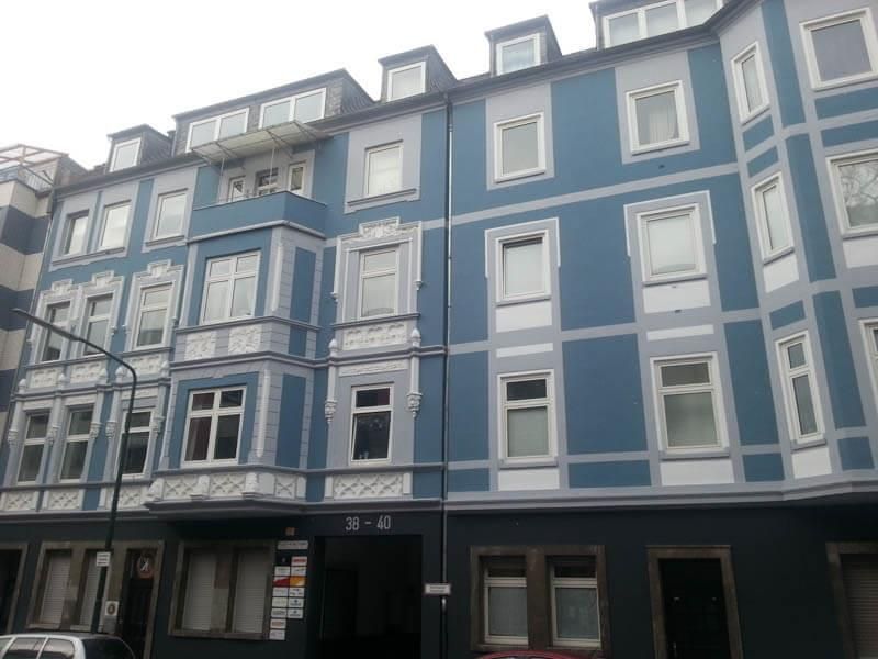 Ein großes blaues Gebäude mit vielen Fenstern