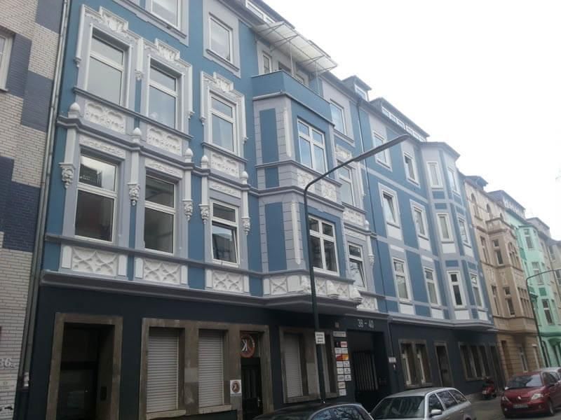 Eine Reihe blau-weißer Gebäude mit davor geparkten Autos