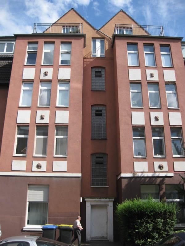 Ein Gebäude mit vielen Fenstern und einem Balkon