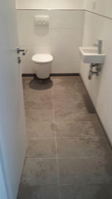 Ein Badezimmer mit Toilette, Waschbecken und Tür.