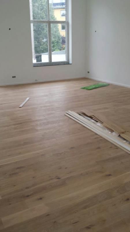 Ein leerer Raum mit Holzboden und Fenster.