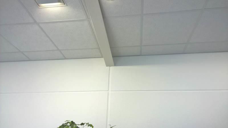 Eine weiße Wand mit einer Decke, auf der sich Quadrate befinden