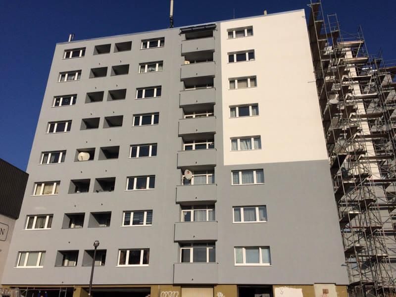 Ein hohes Gebäude mit vielen Fenstern und Balkonen