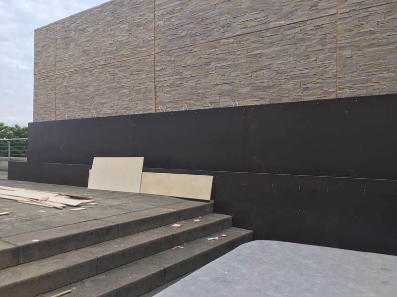 Ein Gebäude mit einer schwarzen Wand und einer Treppe davor