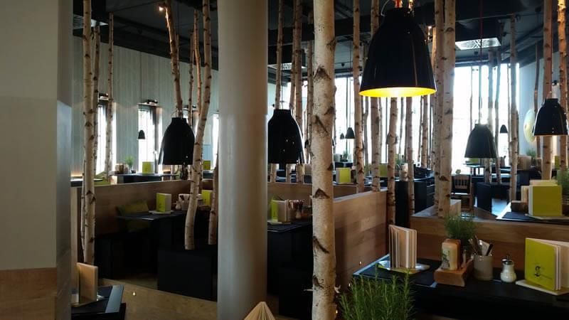 Ein Restaurant mit Birken, die von der Decke hängen