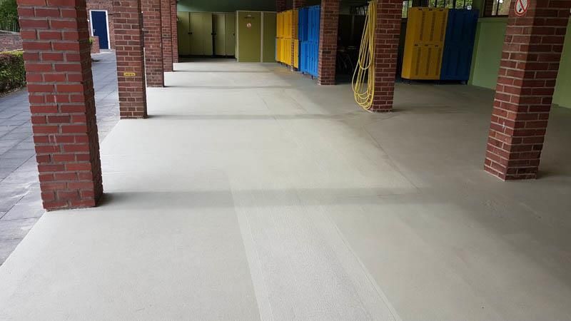 Ein langer Flur mit Ziegelpfeilern und weißem Boden