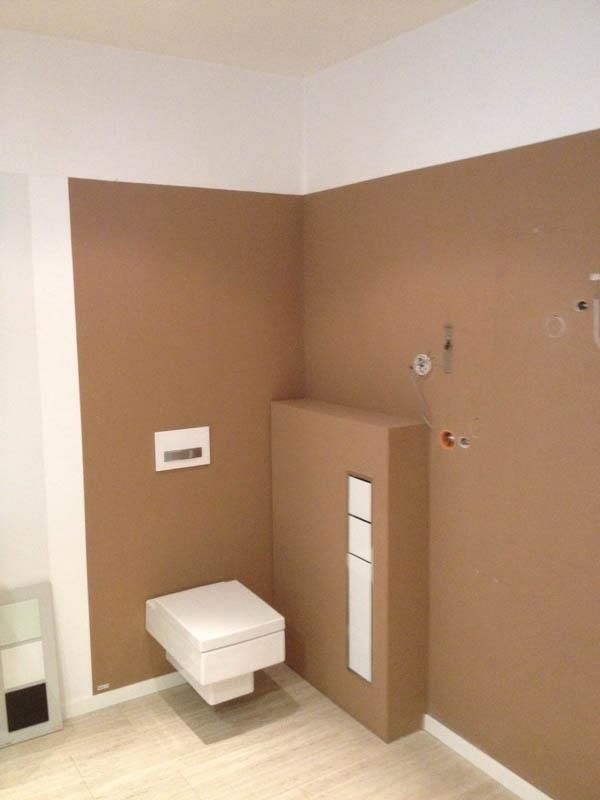 Ein Badezimmer mit braunen Wänden und einer weißen Toilette