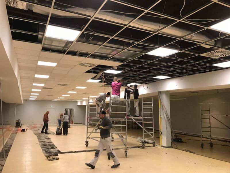 Eine Gruppe von Leuten arbeitet an der Decke eines Gebäudes.