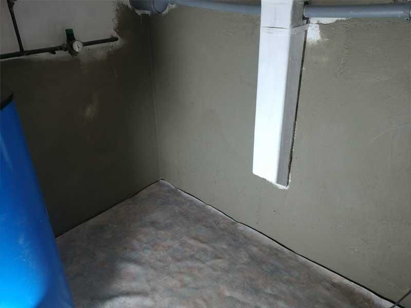 In der ecke des raumes steht ein blaues fass.