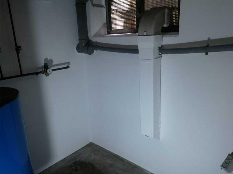 In der ecke des raumes steht ein blaues fass.