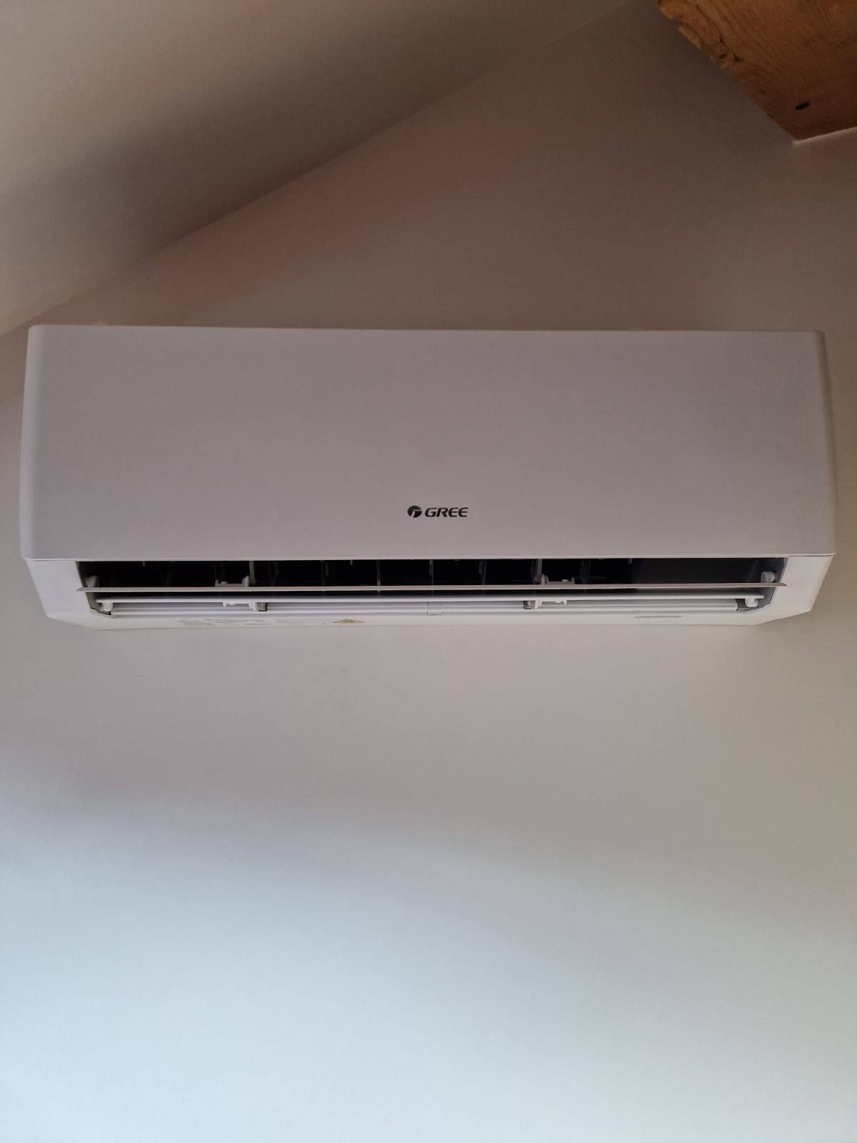 Climatiseur blanc fixé sur un mur blanc.