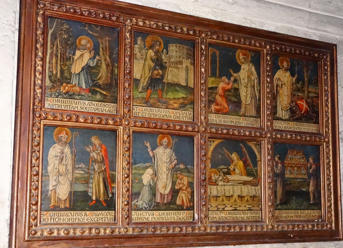 Holzrelief in der Krypta mit einzelnen Stationen aus dem Leben des Hl. Korbinian