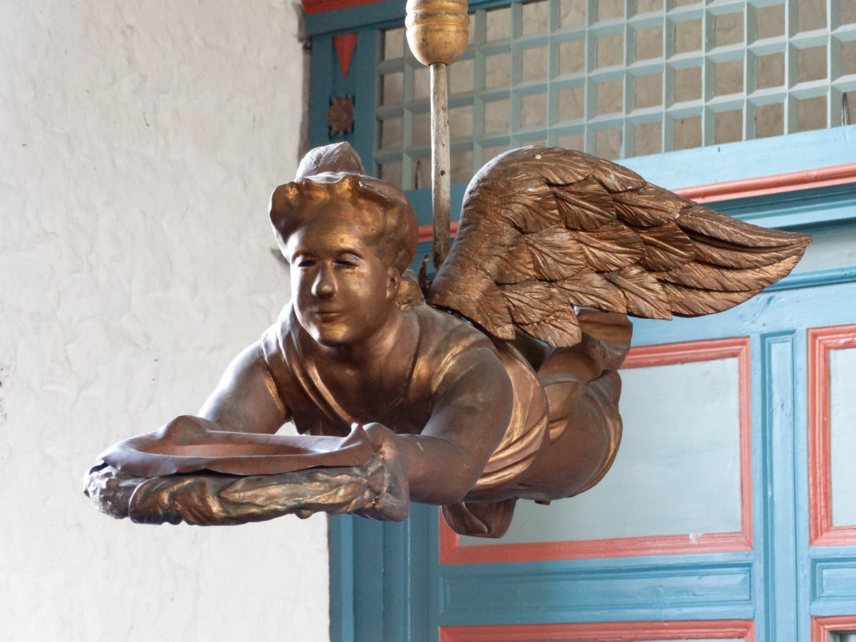 Schwebender Engel über Taufbrunnen