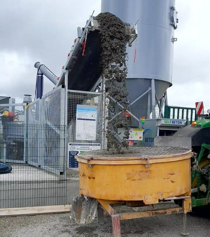 Du béton qui est distribué dans un conteneur jaune