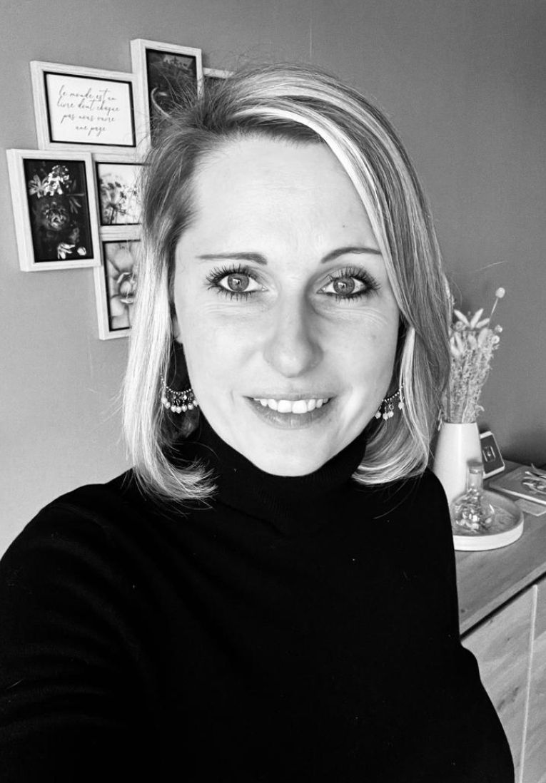 Une femme qui sourit et avec des cheveux courts clairs