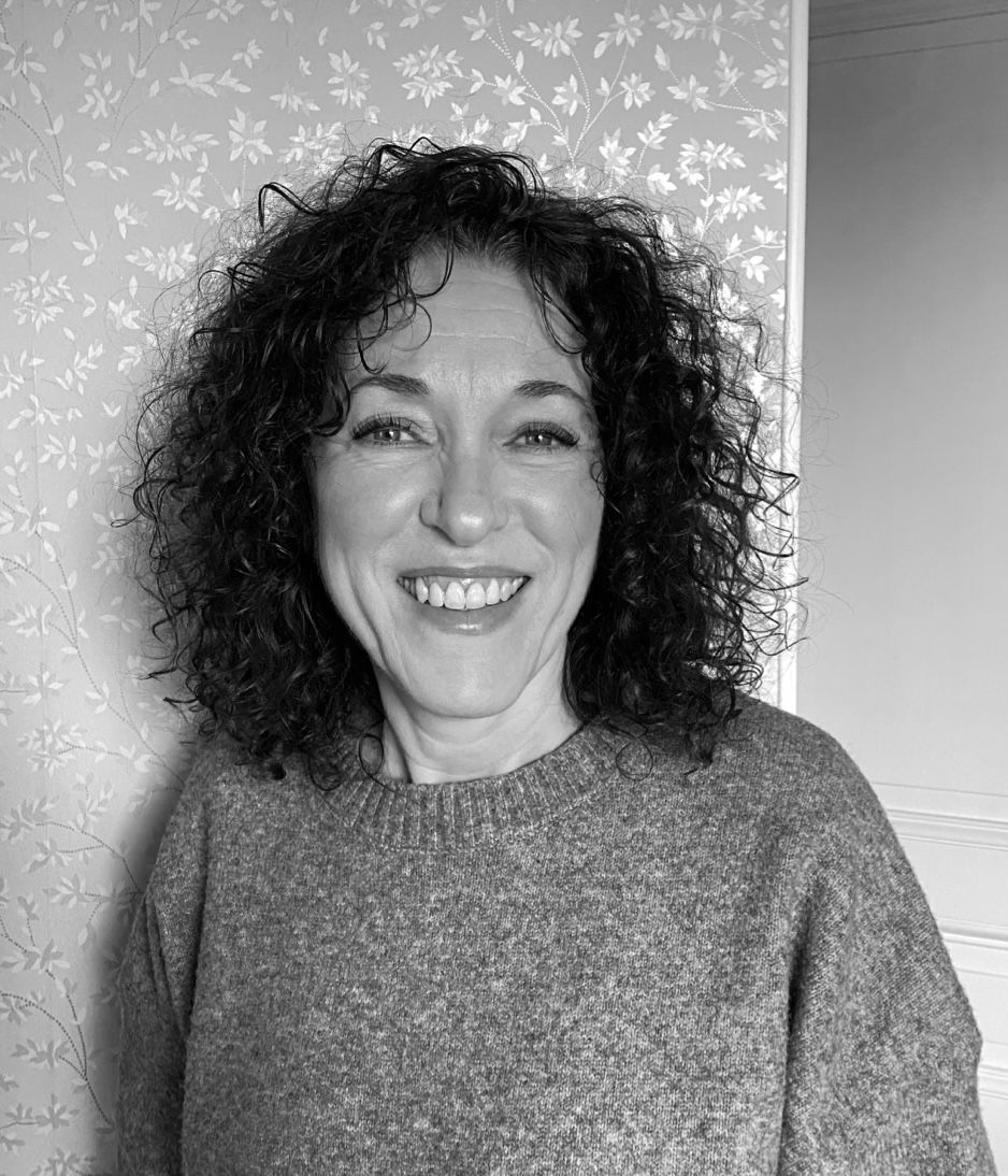 Une femme qui sourit et avec des cheveux bouclés