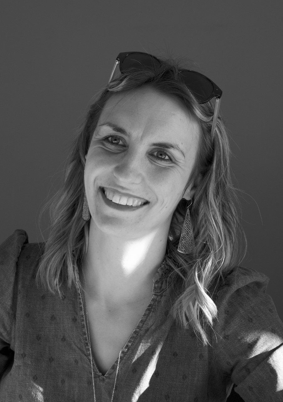 Une femme qui sourit et avec des cheveux longs et qui portent des lunettes