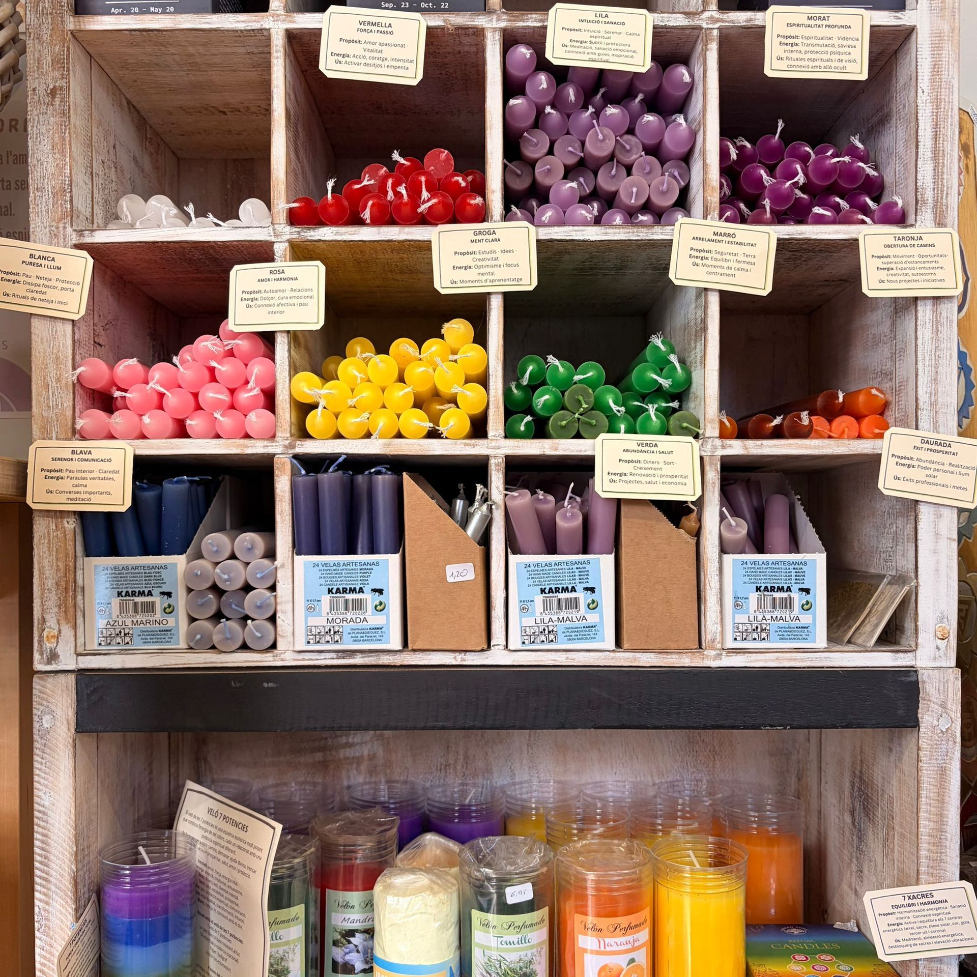 Estante de madera con velas de colores en venta.