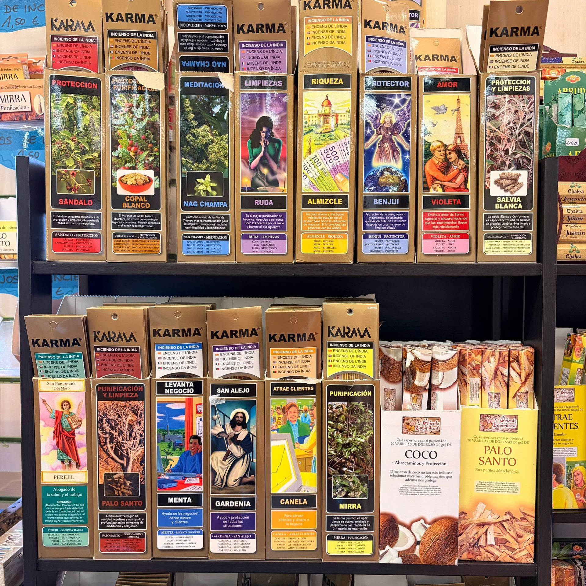 Exhibición en estantería de barritas de incienso Karma, con varias cajas de colores.