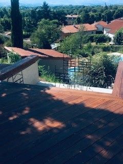 Terrasse en bois avec vue sur maisons et arbres