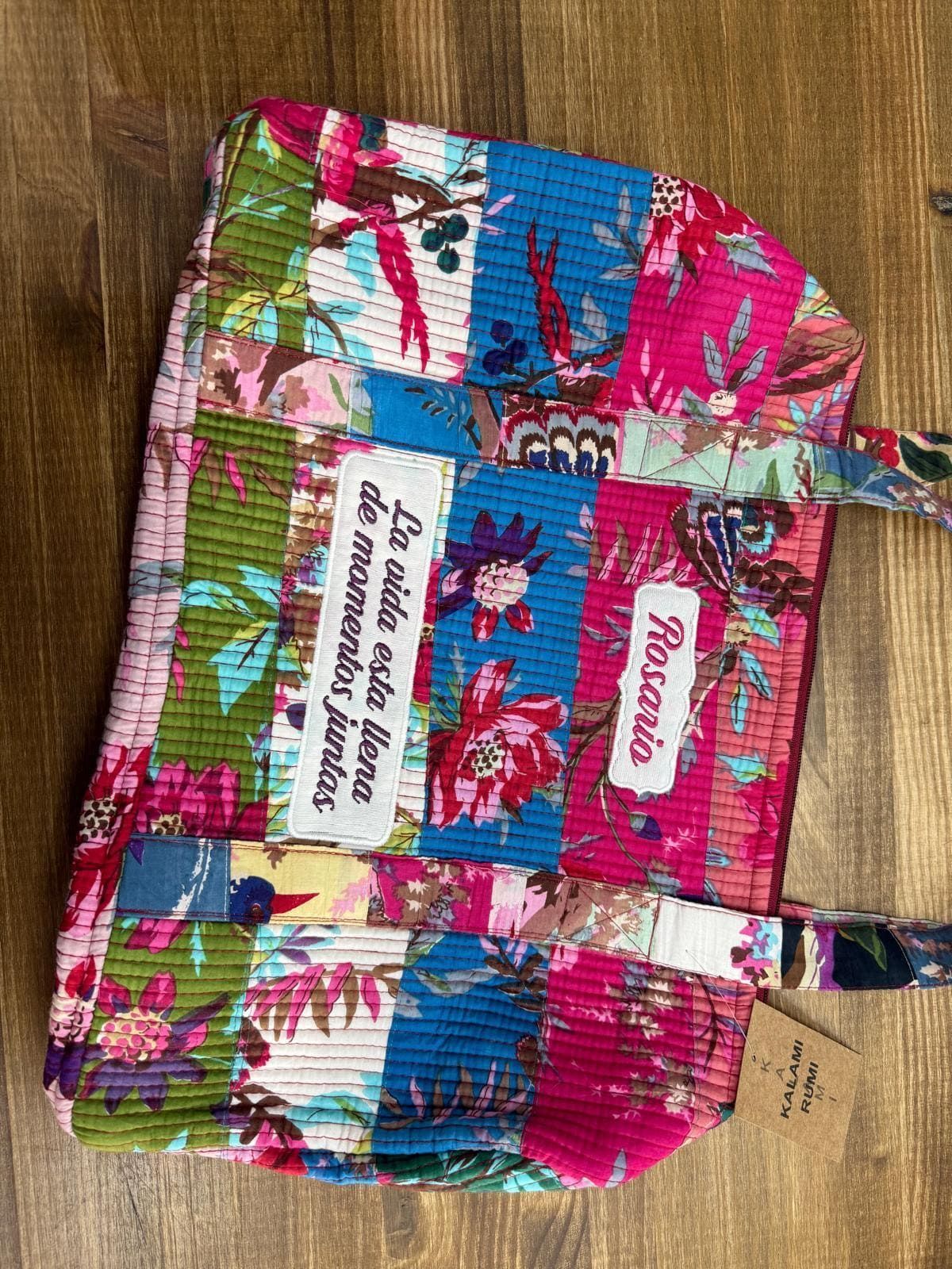 Un bolso colorido está sobre una mesa de madera.