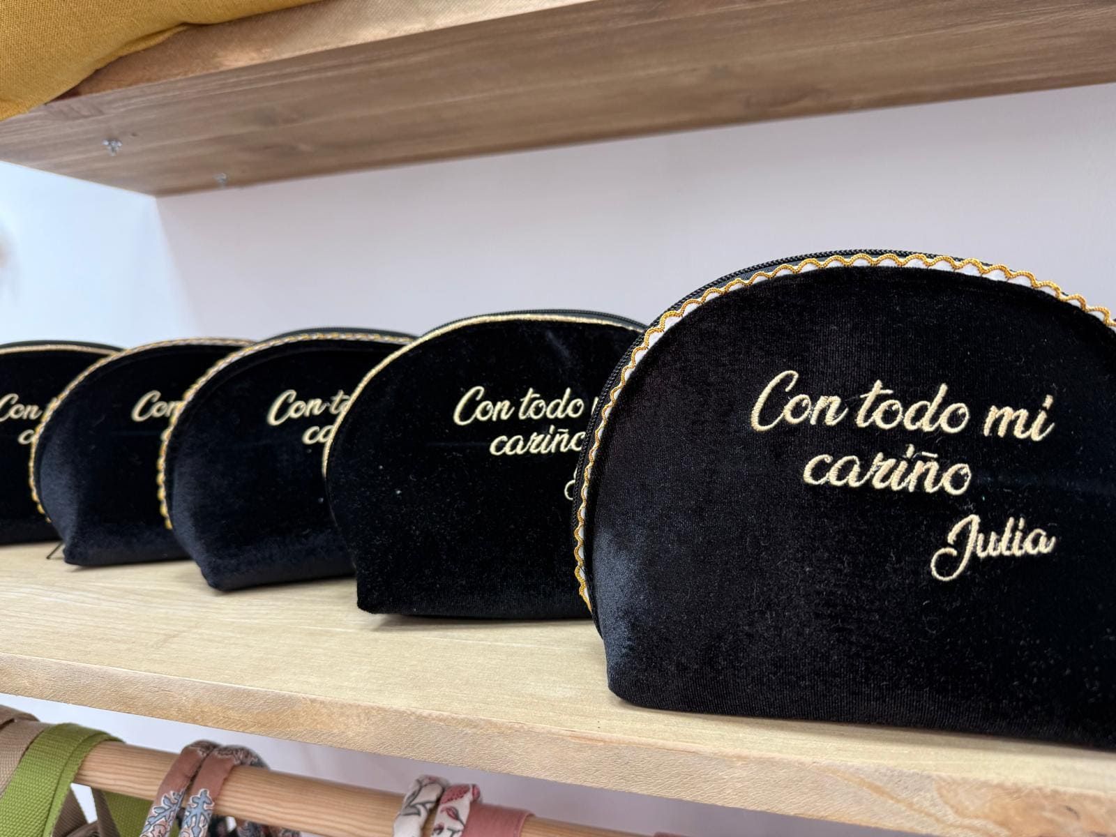 Una fila de bolsas de cosméticos negras que dicen