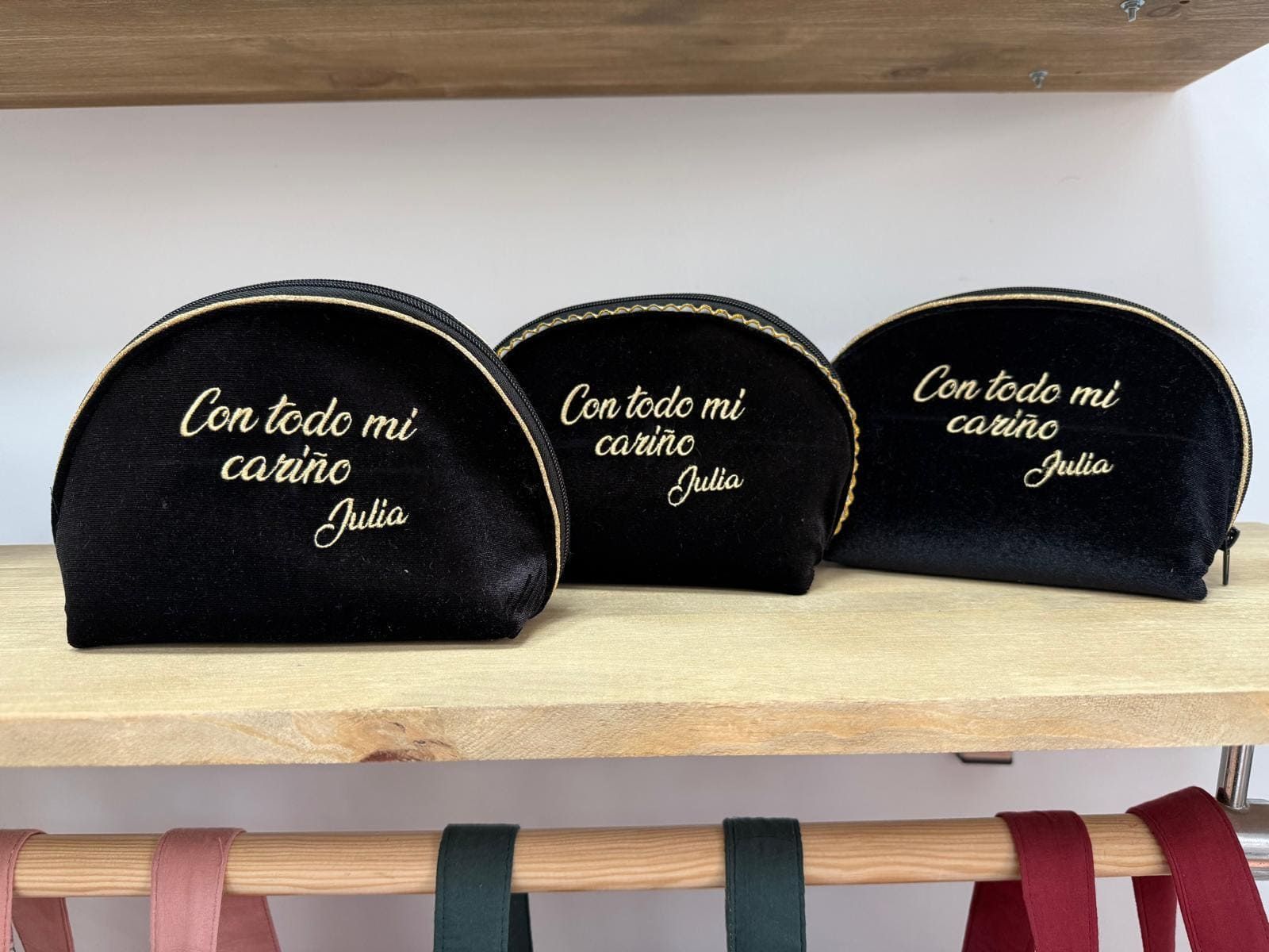 Tres bolsas de cosméticos negras que dicen