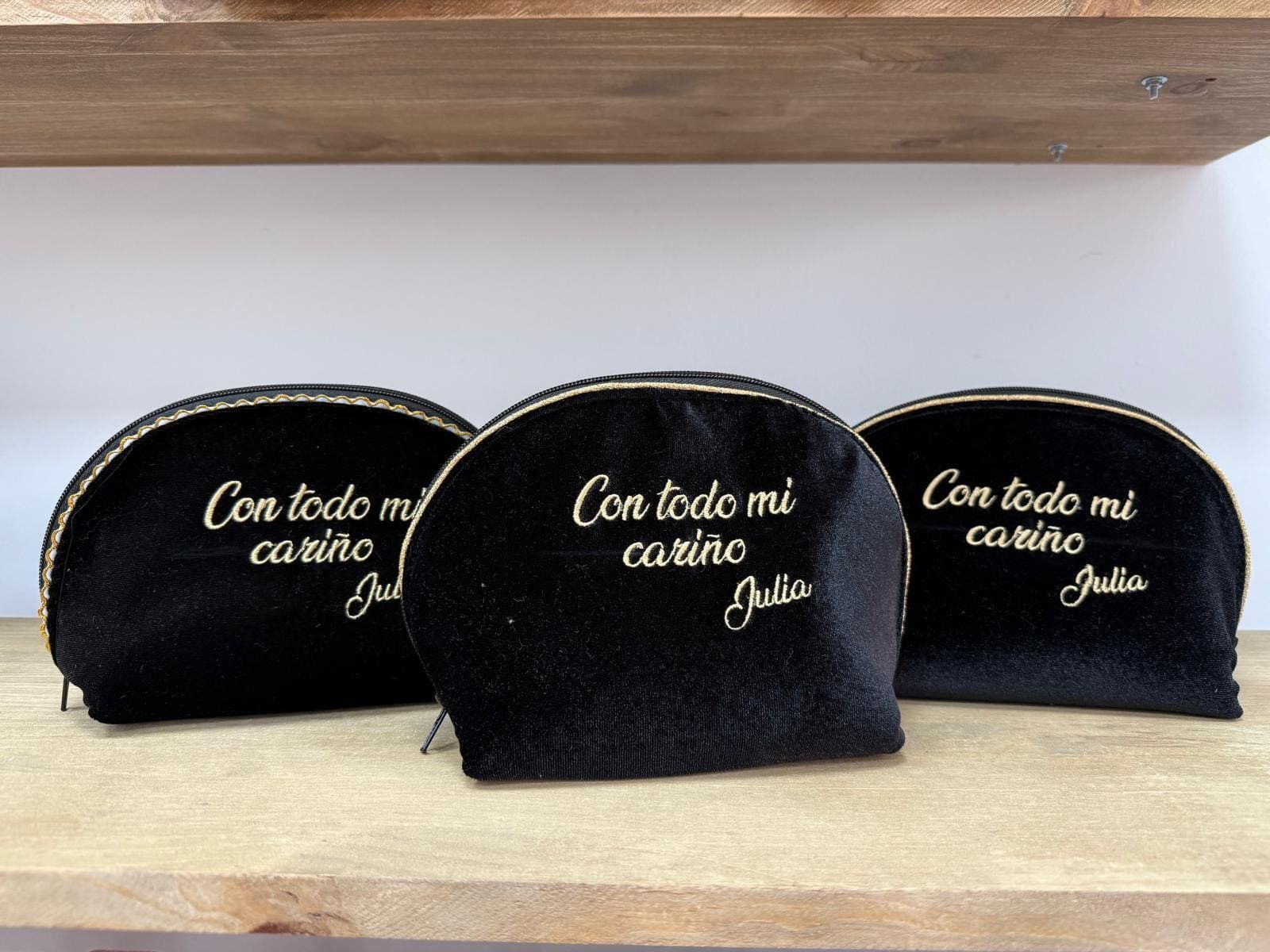 Tres bolsas de cosméticos negras que dicen