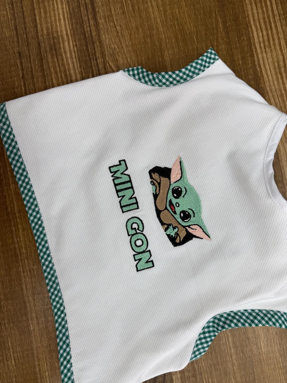 Una camiseta blanca sin mangas con un Baby Yoda bordado.