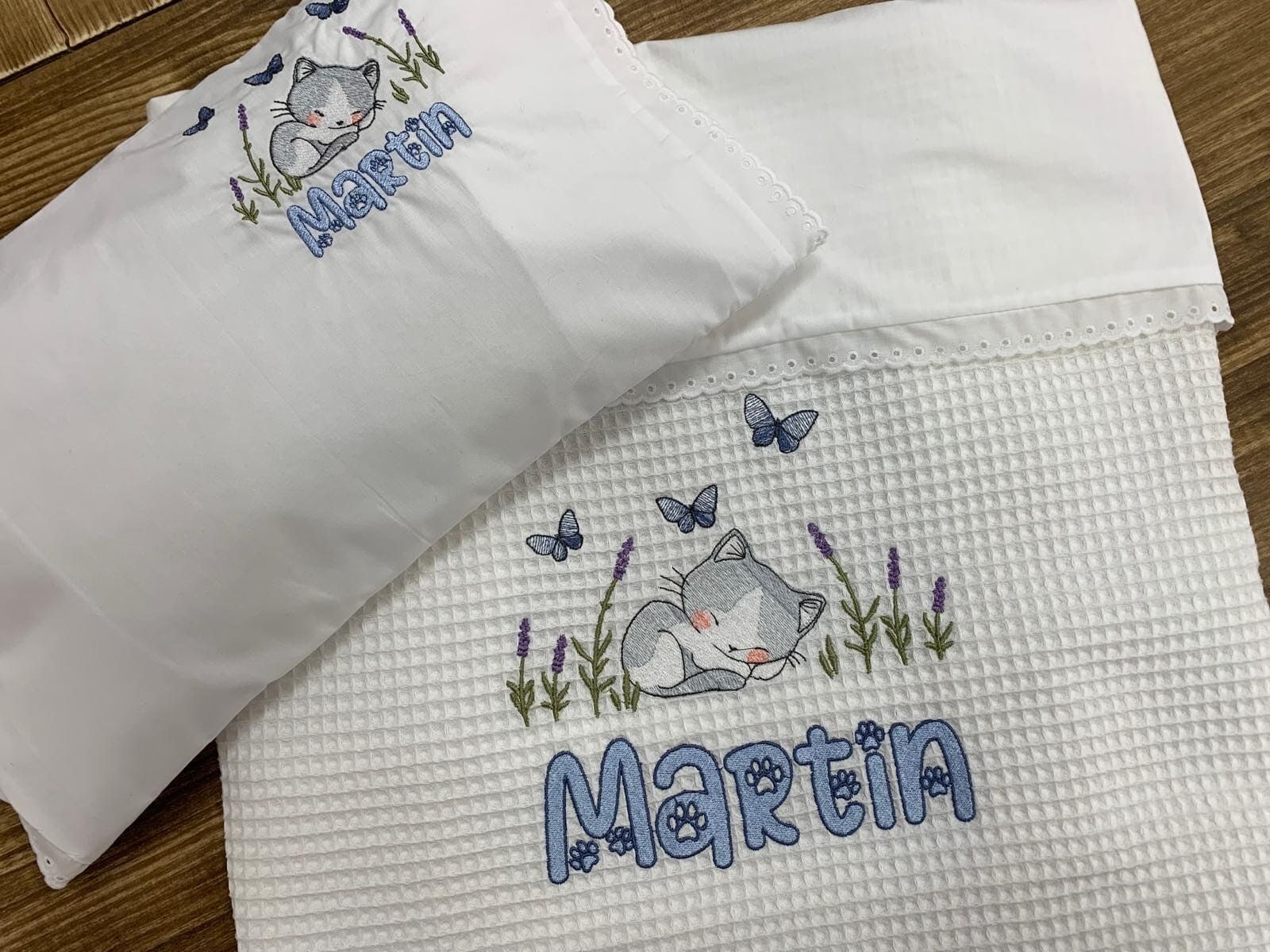 Una manta de bebé y una almohada con el nombre Martina bordado en ellas.