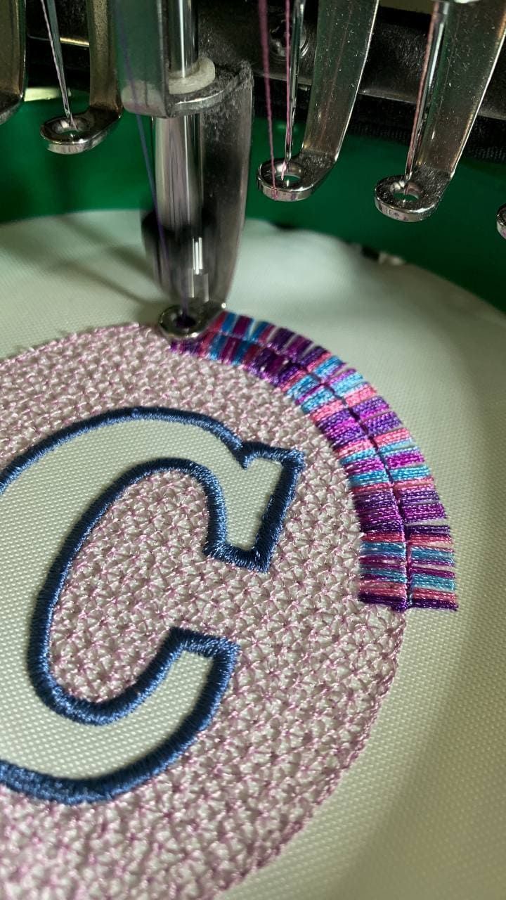 Un primer plano de una máquina de coser con una letra c en ella.