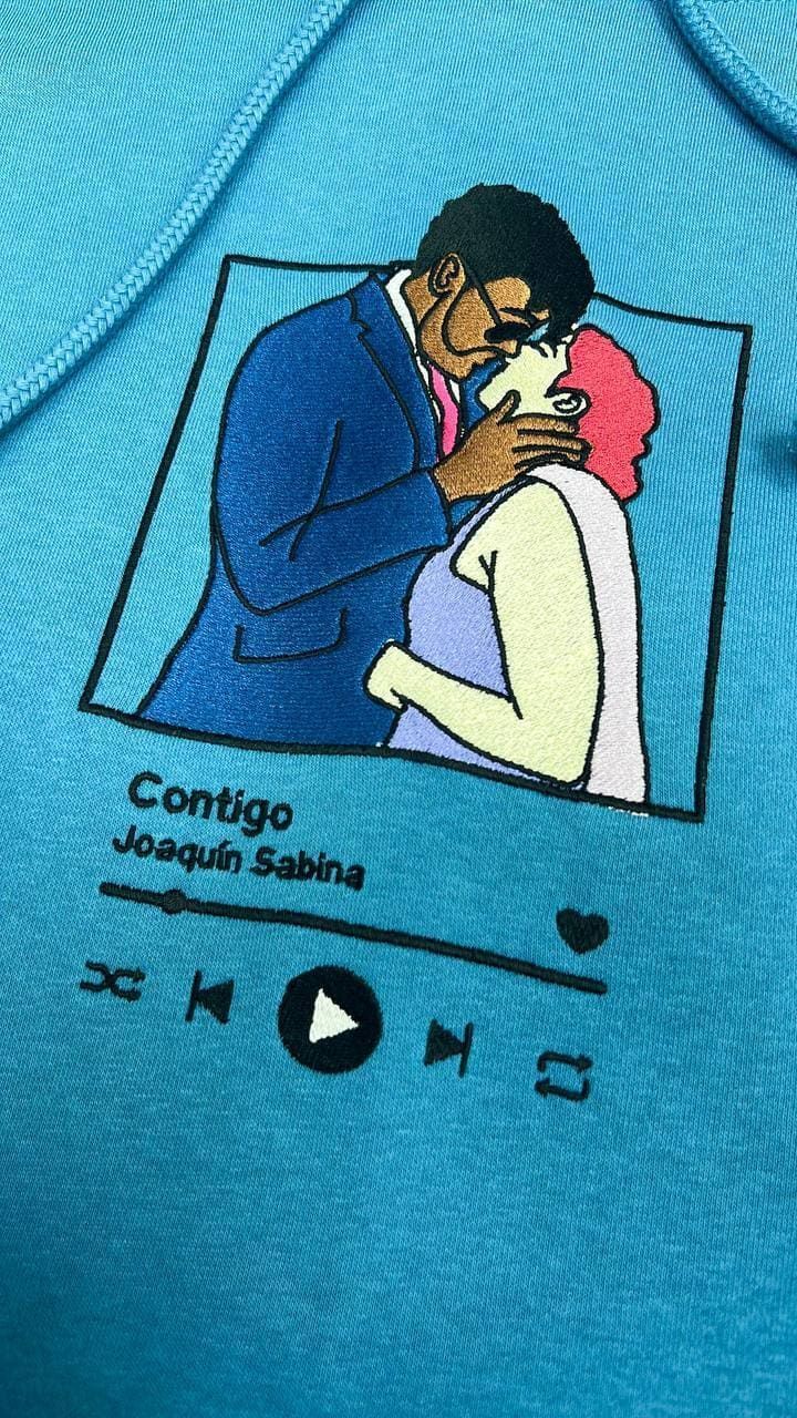 Una camisa azul con una imagen de un hombre y una mujer besándose.