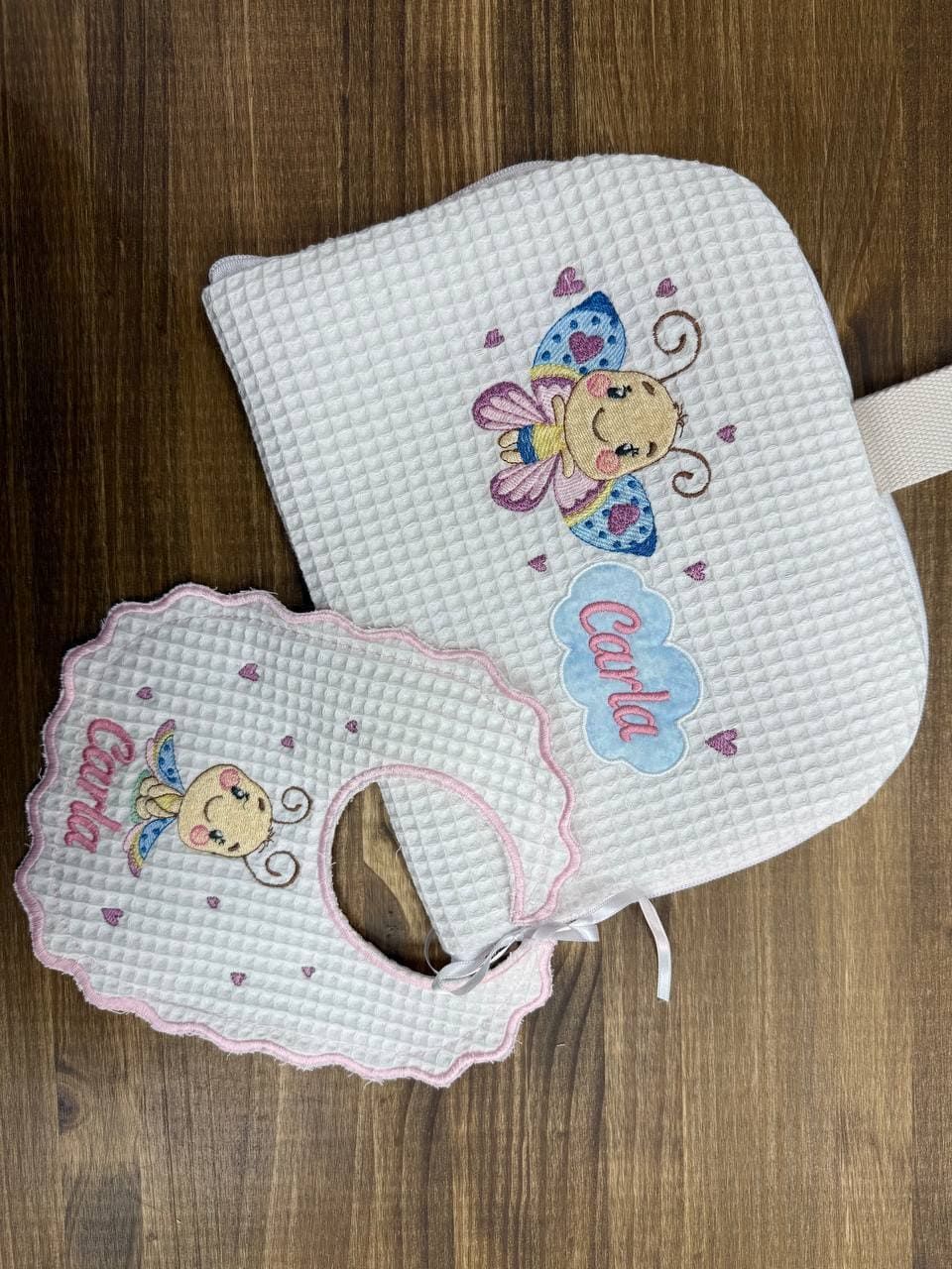 Un babero y una almohada están sobre una mesa de madera.