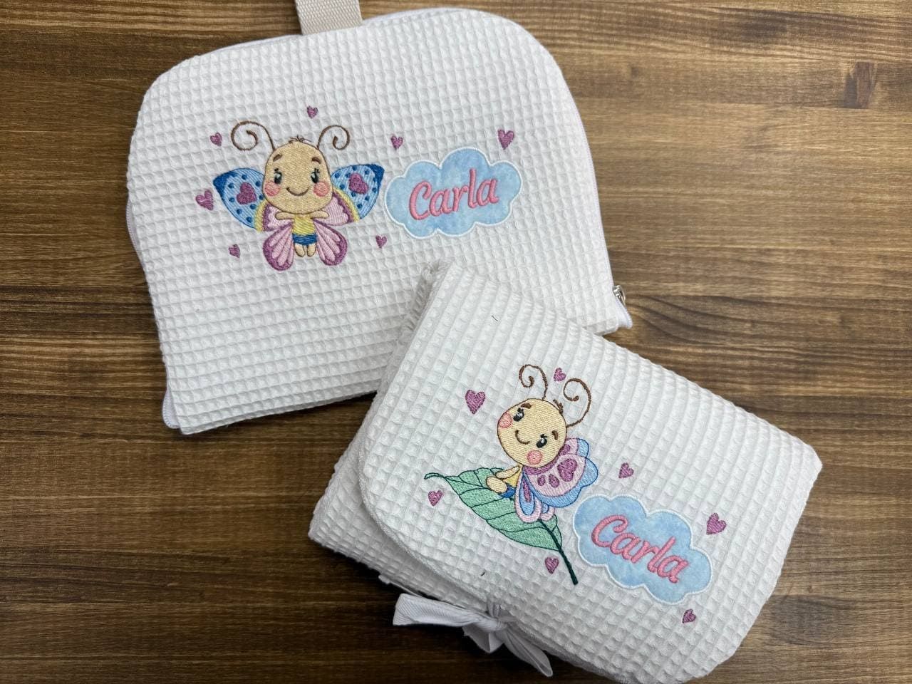 Un par de bolsas con mariposas están sobre una mesa de madera.