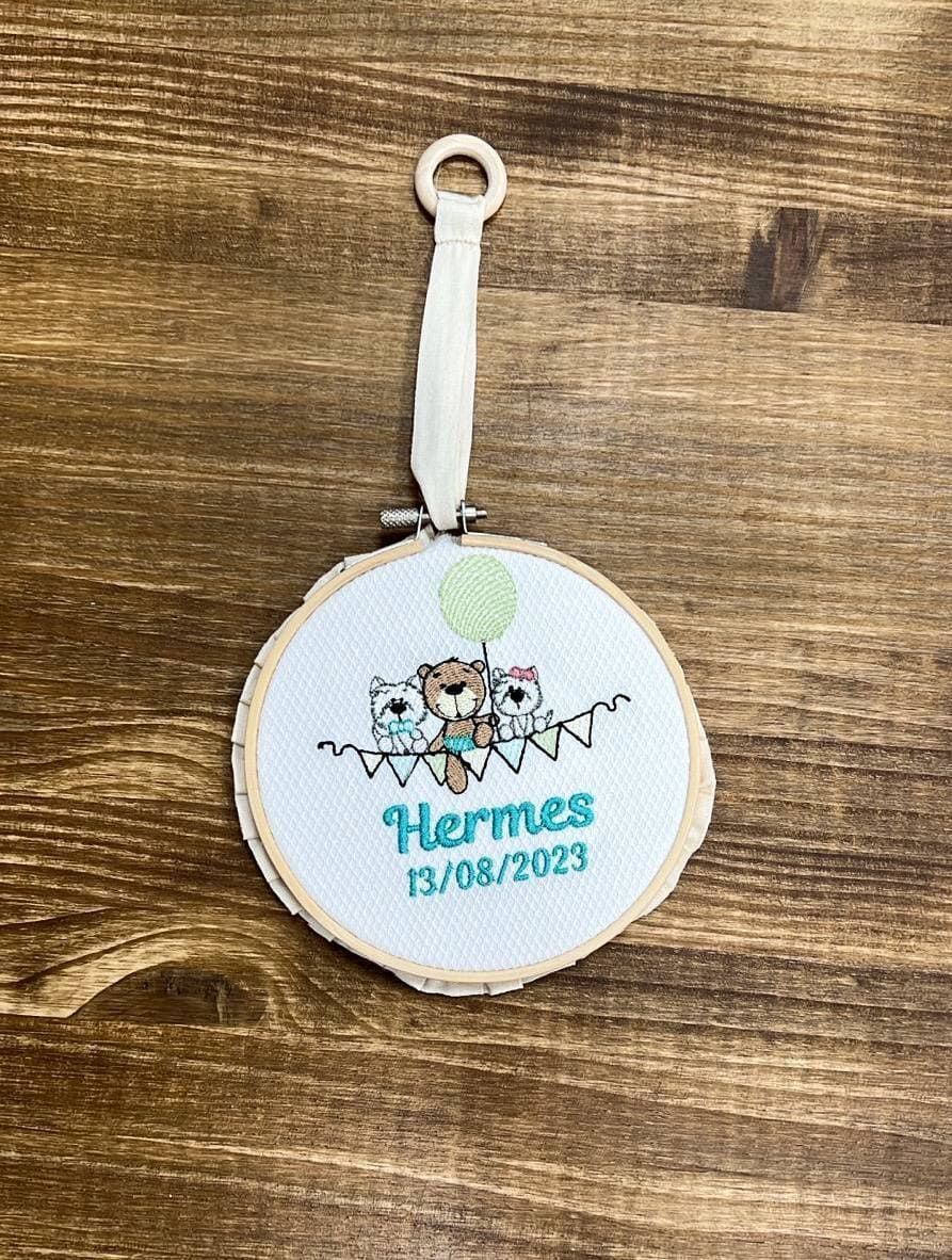 Un adorno de punto de cruz está sobre una mesa de madera.